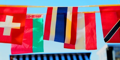 An assortment of small European flags hanging down from a string that connects them