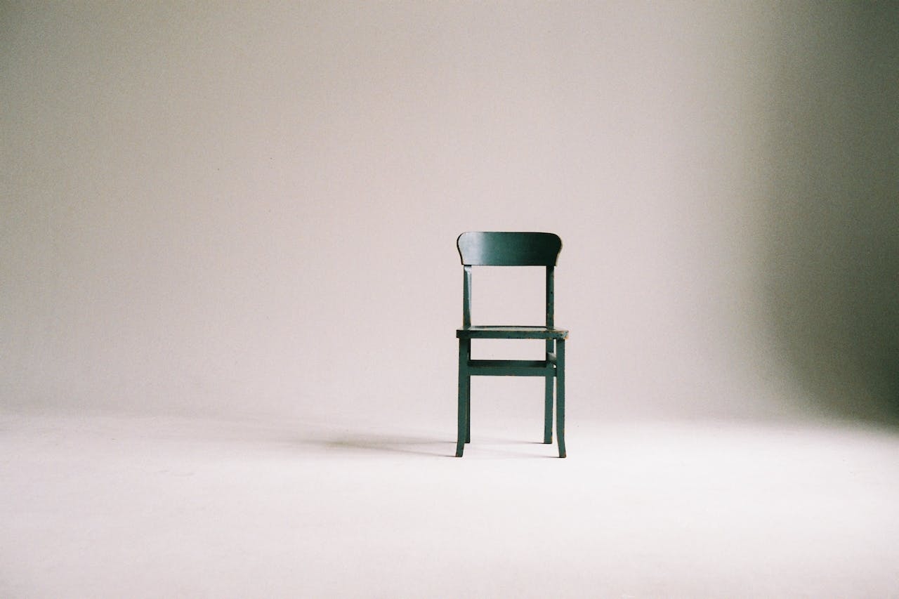 Green, wooden chair against a white background