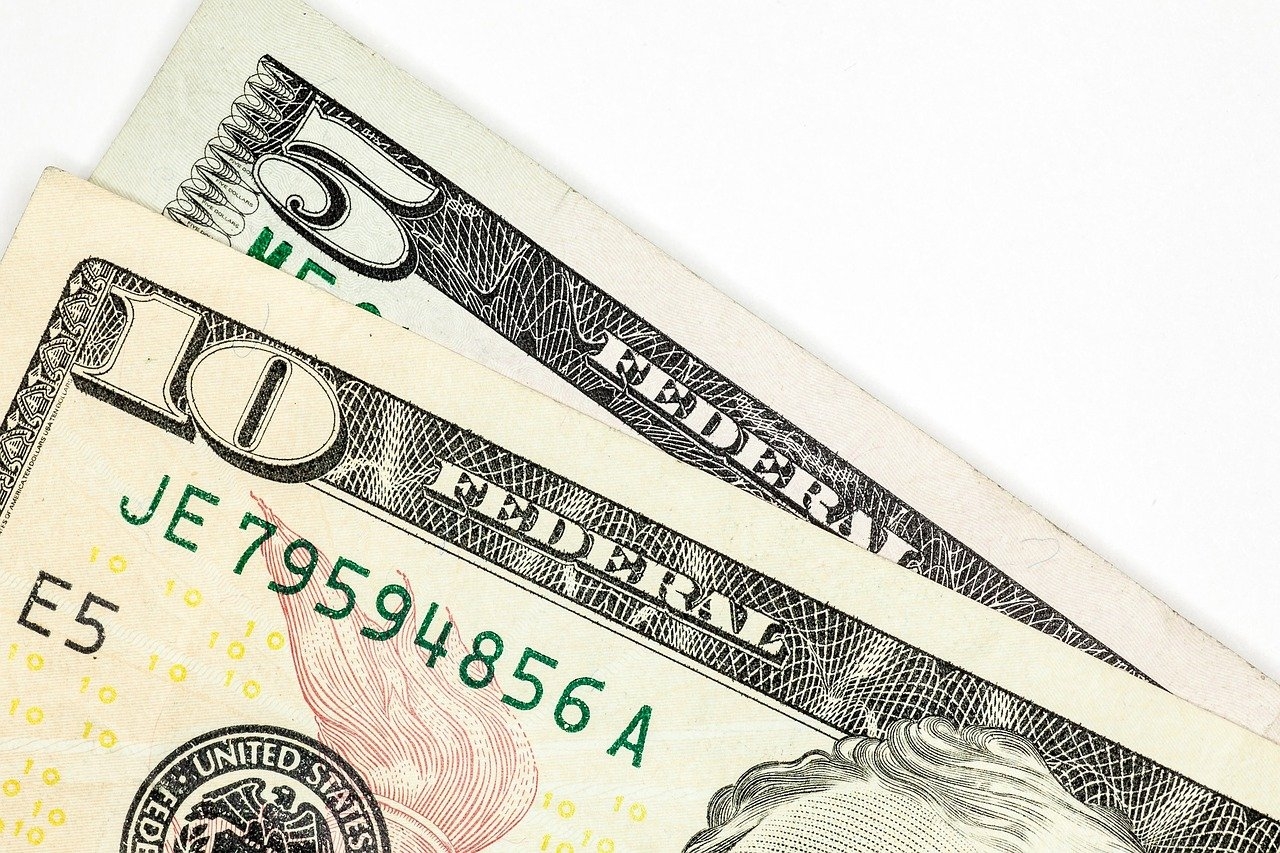 Closeup photo of a five and ten dollar bill.