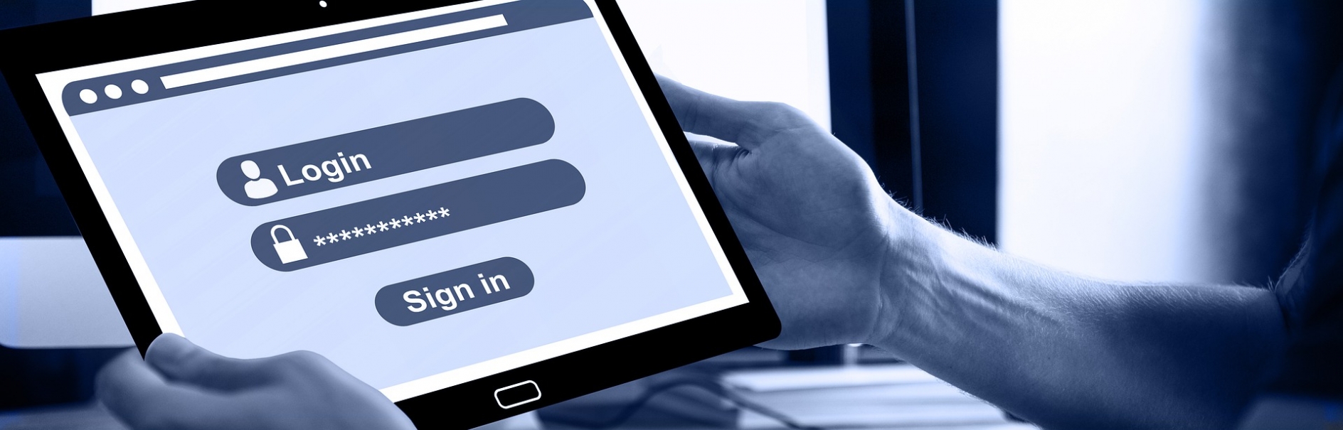 Man holding a tablet computer displaying a login page