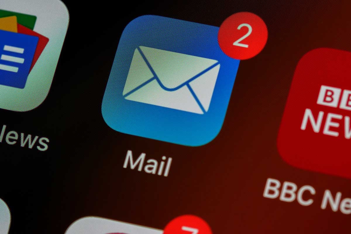 closeup photo of the mail app icon on an iPhone, showing two unread emails