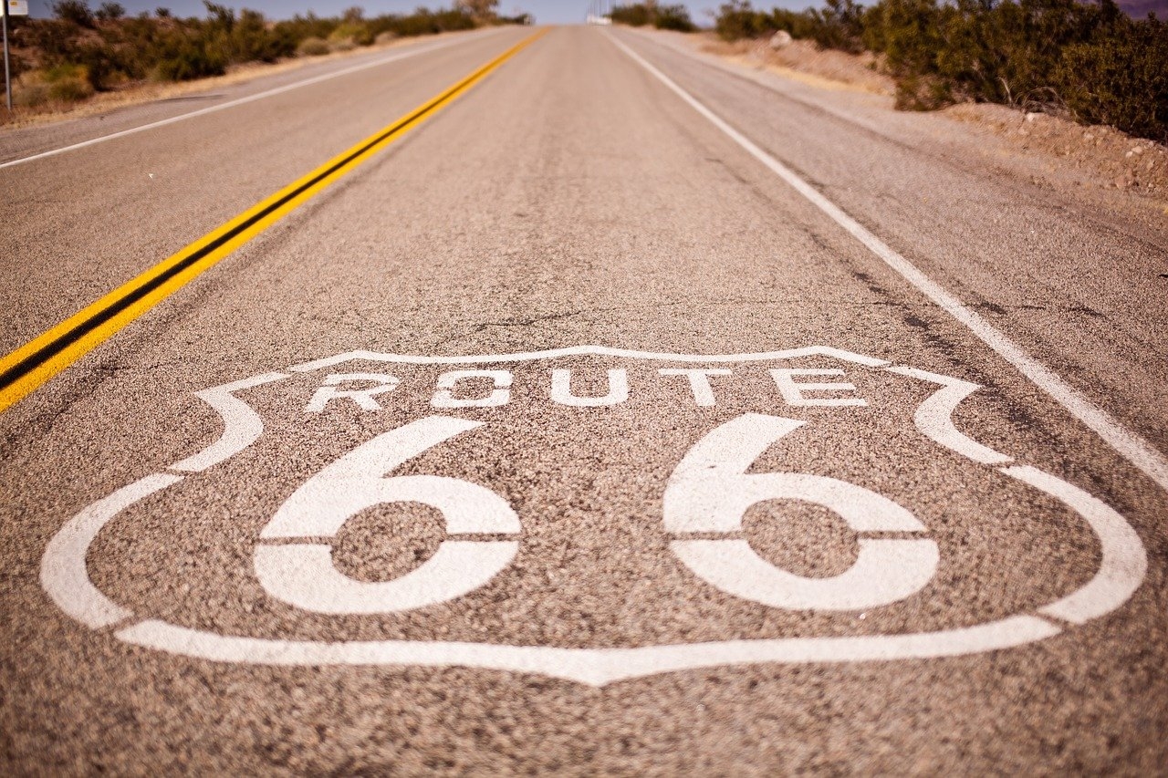 Photo of the surface of a highway with route 66 painted on it in white
