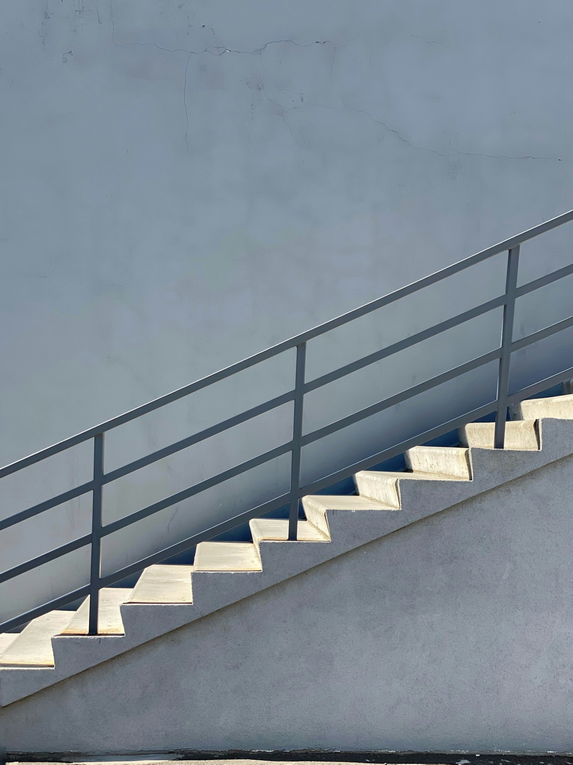A white staircase with a gray railing