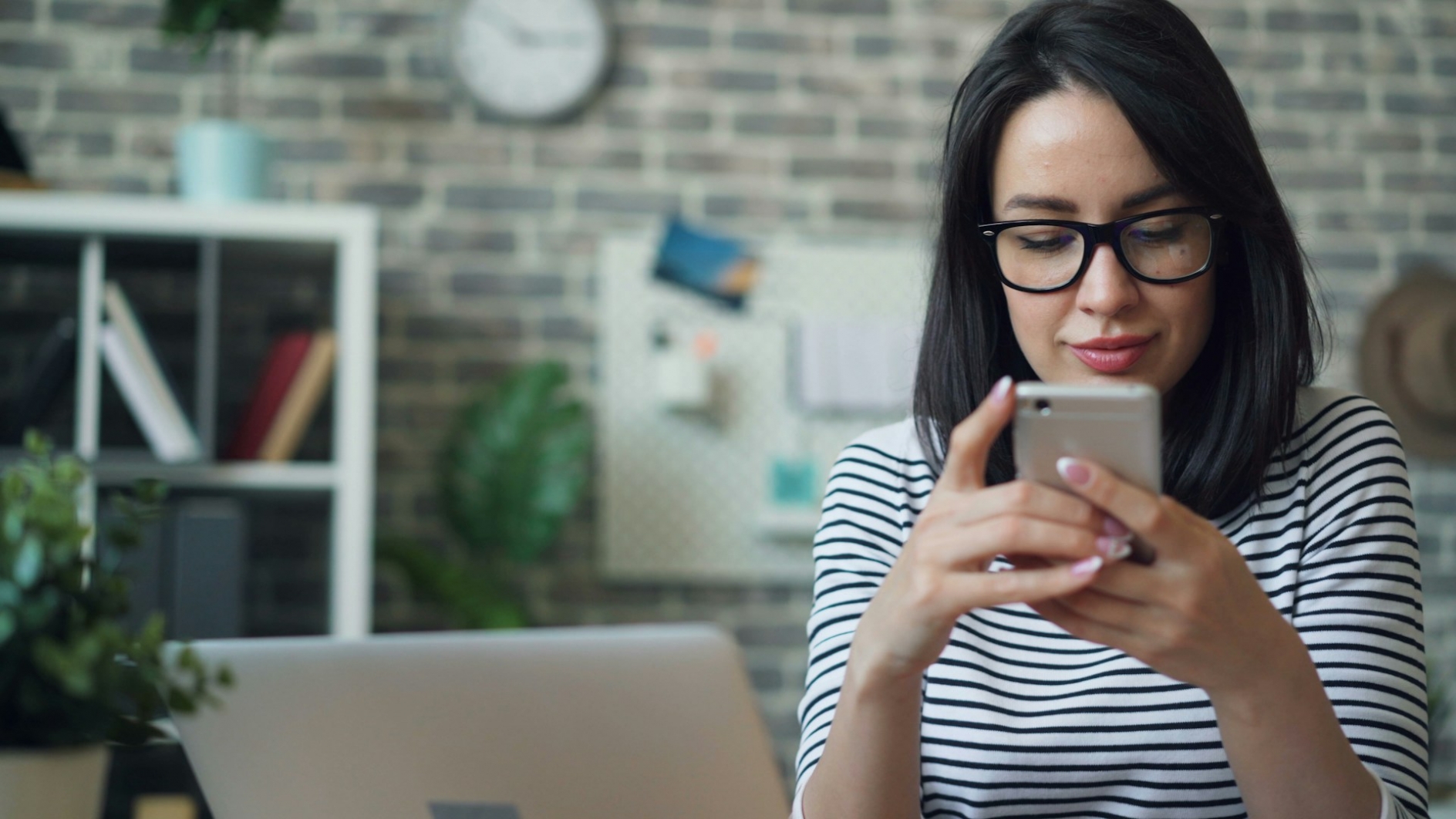 a woman sitting at a table looking at her cell phone