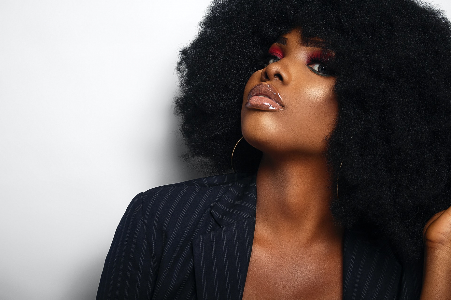 A young black woman with a large afro, wearing a business suit